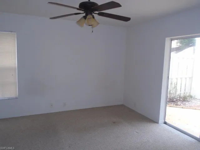 Carpeted spare room with ceiling fan