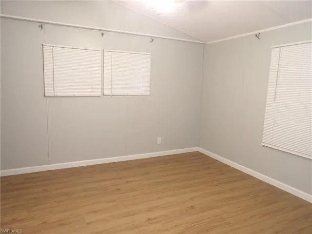 Primary room featuring vaulted ceiling and laminated floors