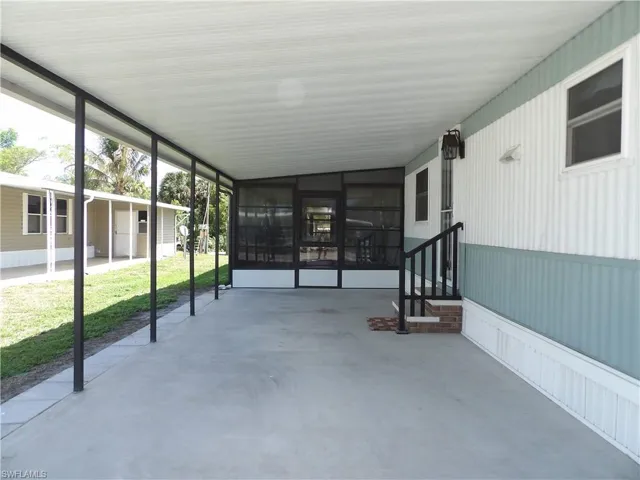 View of patio featuring a sunroom and an attached carport