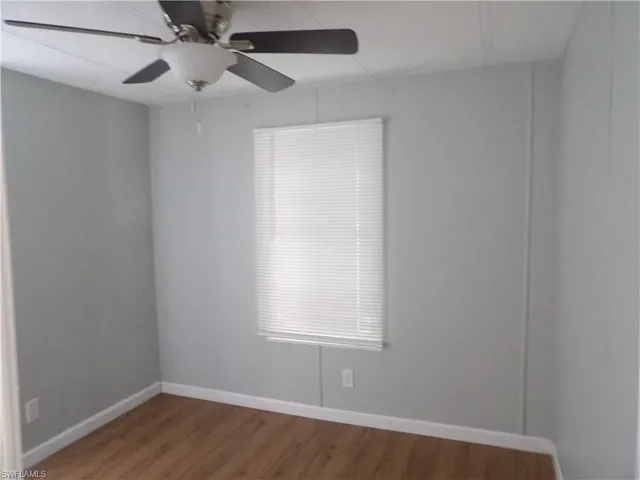 Spare room with laminated floors and a ceiling fan