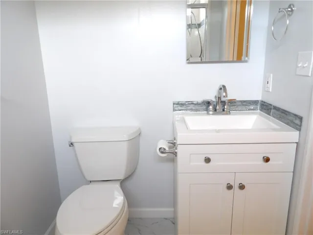 Updated Primary Bathroom with vanity and light marble finish floors