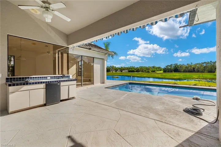 The lanai features an under-truss area equipped with water and electric connections for an outdoor kitchen. Updating is needed with the current outdoor kitchen area.