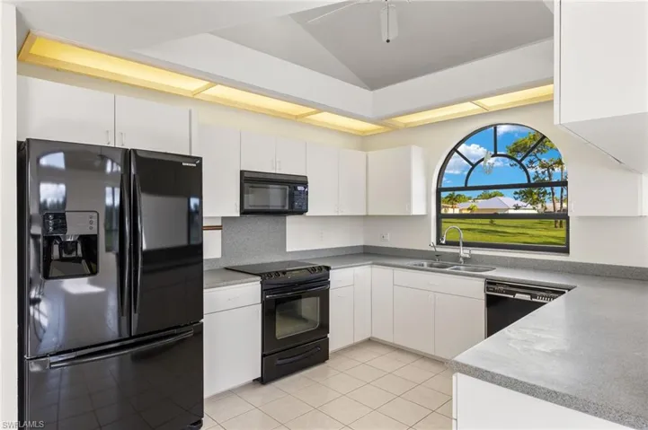 White cabinets and Corian countertops offer ample storage and workspace for all your meal preparations.