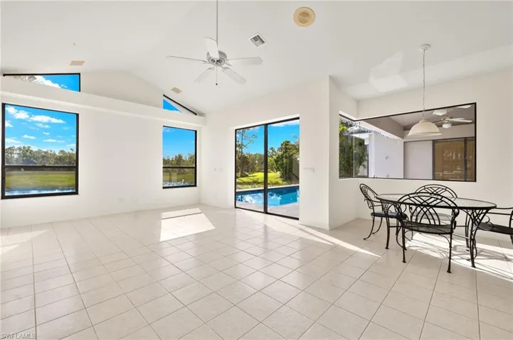 The vaulted family room is bathed in natural light and offers stunning views of nature, thanks to the large windows, pocketing sliding glass door, and zero corner window