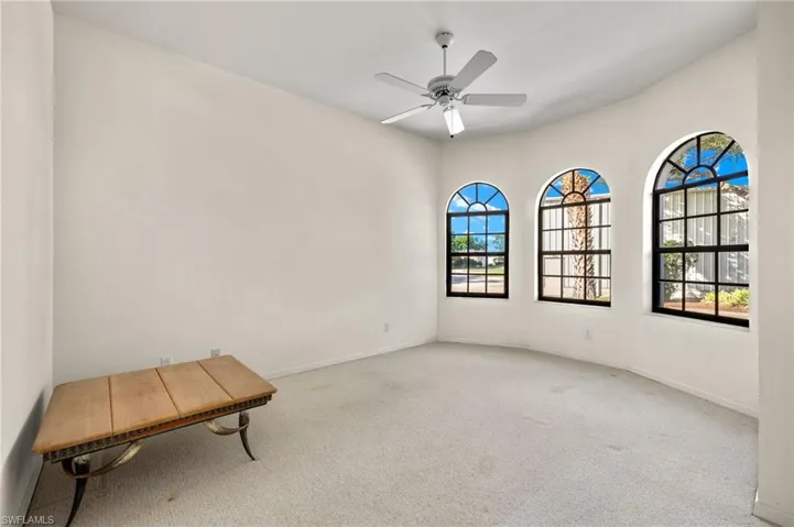 Arched windows bathe the office/den in natural light, making it perfect for a craft room, playroom, or quiet reading area.