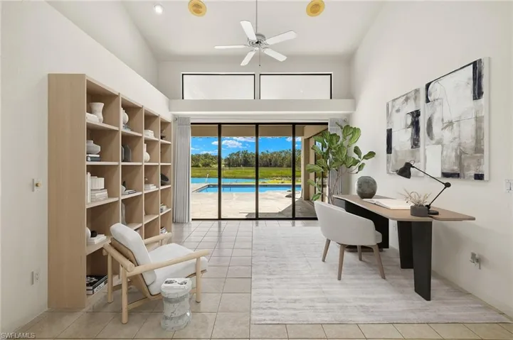 Virtually staged Living Room functioning as office space with high vaulted ceiling and abundant views of nature.