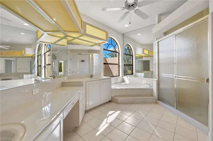 The owner's spacious ensuite bathroom features a separate shower and a luxurious soaker tub. A large window, complemented by a privacy wall, ensures plenty of natural light floods the space while maintaining privacy.
