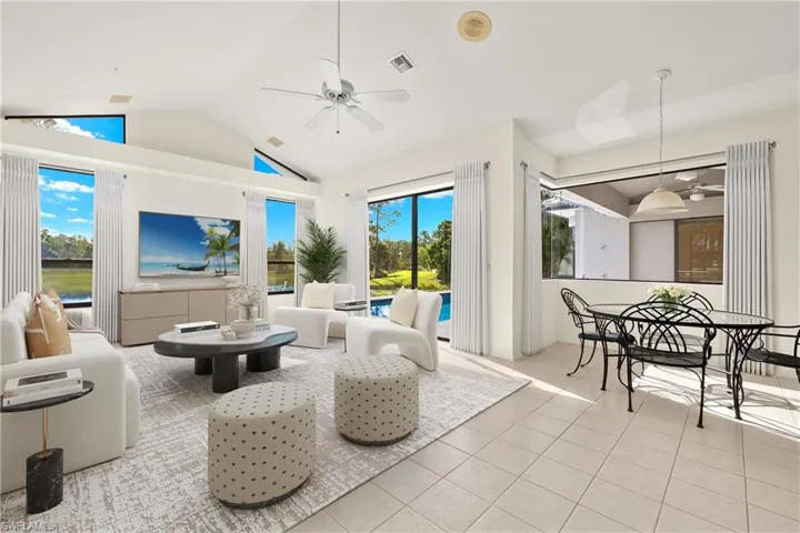Family room featuring high vaulted ceiling, ceiling fan, and light tile floors. Virtually Staged.