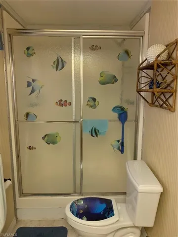 Bathroom featuring toilet and a stall shower