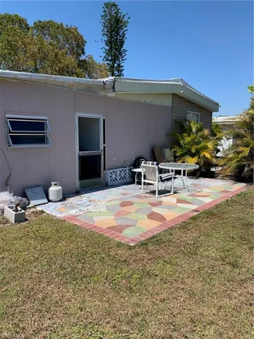 Rear view of house with a patio and a lawn