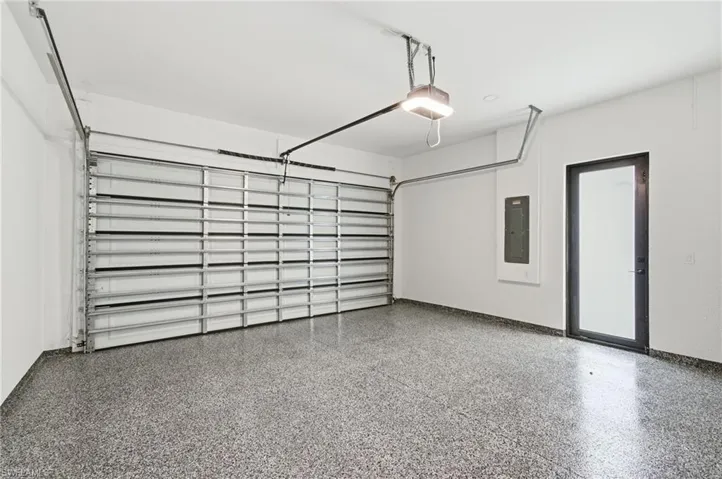 Garage with electric panel and a garage door opener