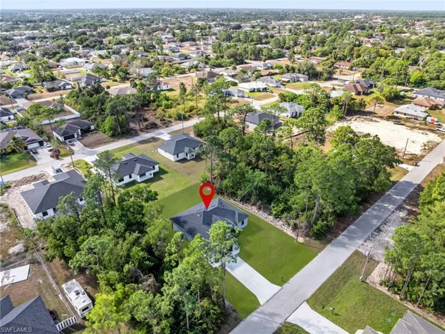 Aerial view of property and surrounding area with nearby suburban area