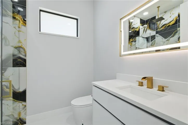 Full bath with vanity and a marble finish shower
