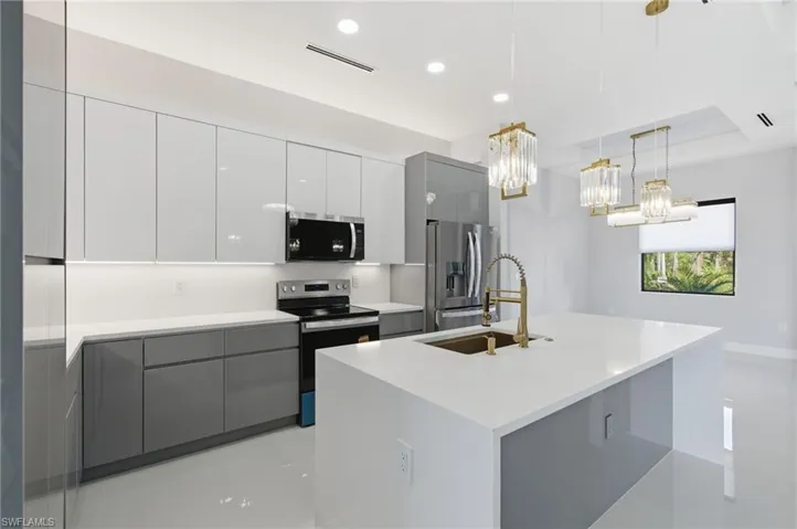 Kitchen featuring gray cabinets, modern cabinets, stainless steel appliances, decorative light fixtures, and recessed lighting