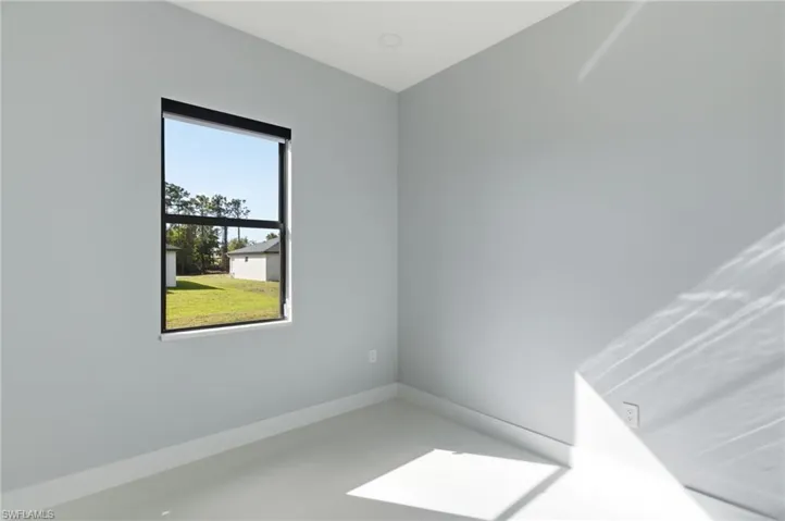 Spare room featuring baseboards and concrete floors