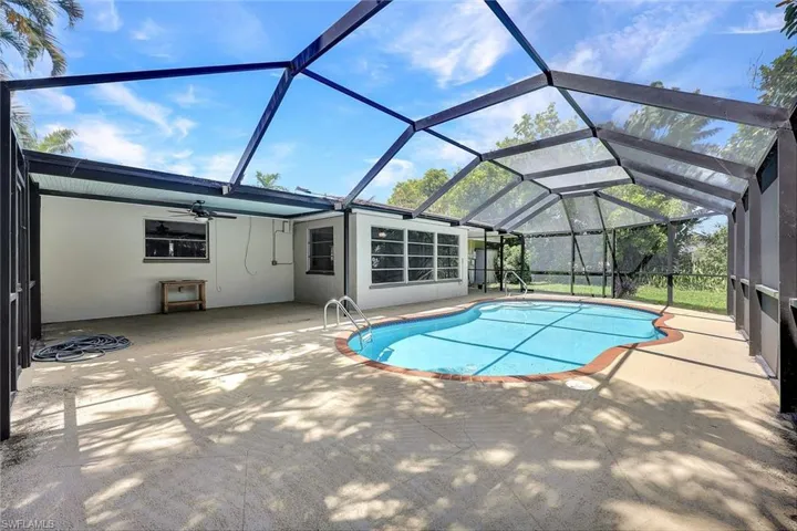 View of pool with ceiling fan, a lanai, and a patio area