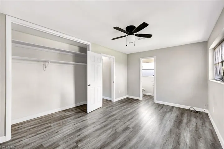 Unfurnished bedroom with ceiling fan, a closet, hardwood / wood-style flooring, and ensuite bathroom