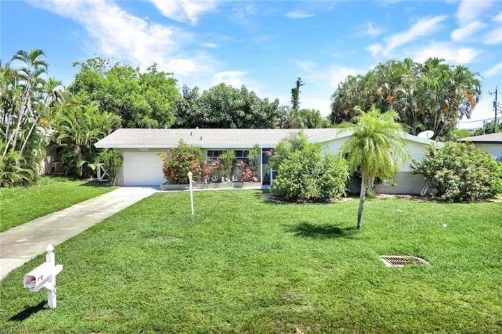 Ranch-style home featuring a garage and a front lawn