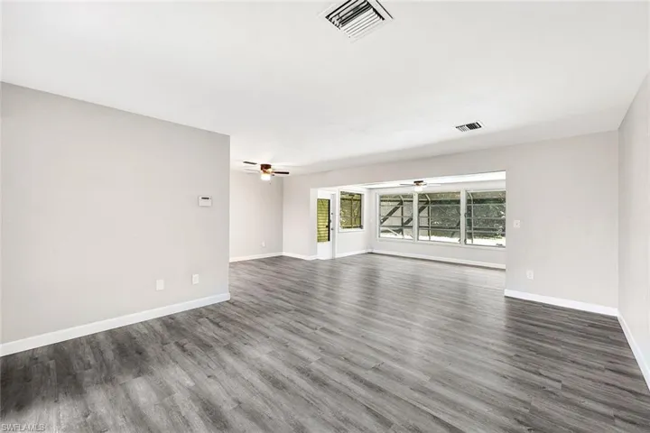 Unfurnished room with ceiling fan and wood-type flooring