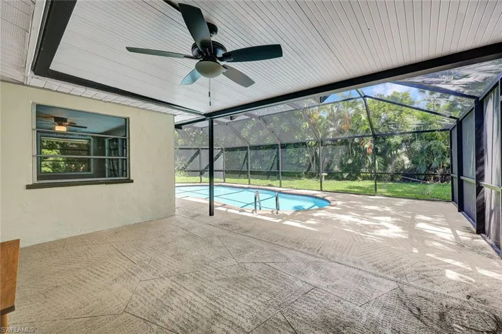 View of pool with ceiling fan, a patio area, and a lanai
