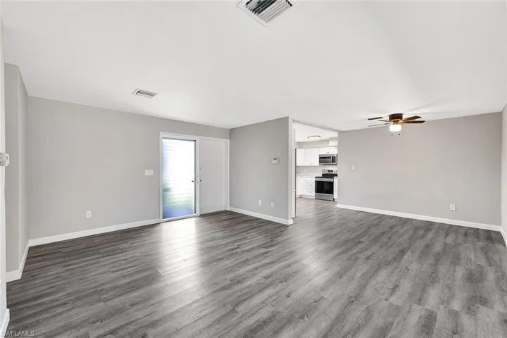 Unfurnished living room featuring ceiling fan and hardwood / wood-style flooring