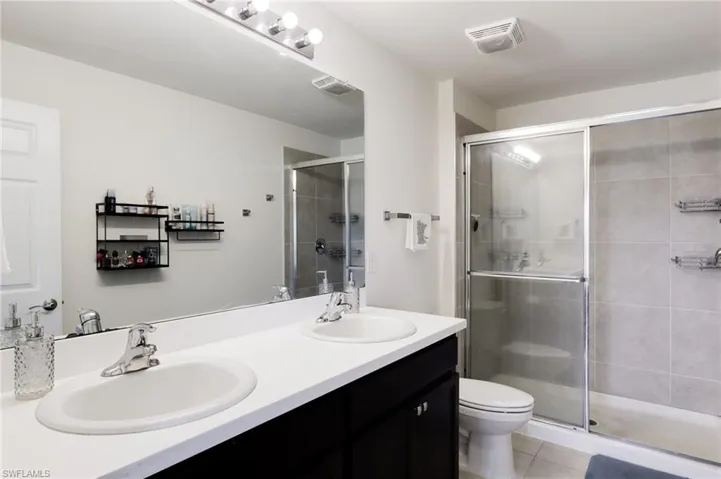 Bathroom with vanity, tile patterned floors, toilet, and walk in shower