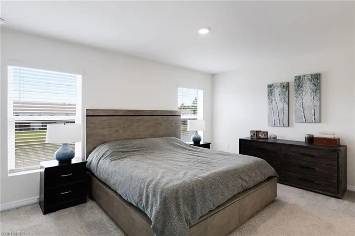 Bedroom featuring light colored carpet