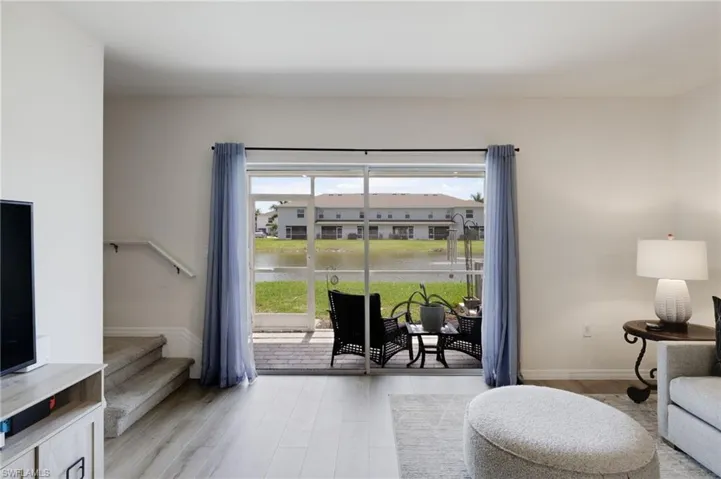 Living room with a water view, a healthy amount of sunlight, and light hardwood / wood-style floors