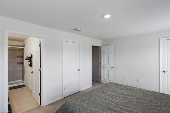 Carpeted bedroom with connected bathroom