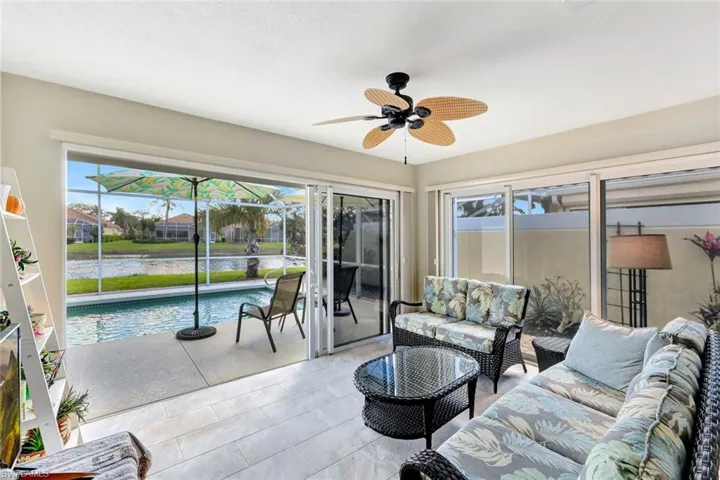 Sunroom / solarium with a water view, a ceiling fan, and a wealth of natural light