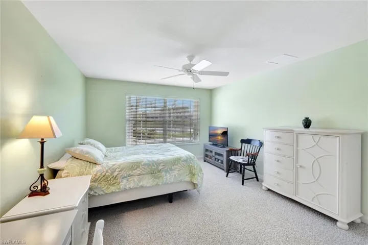 Bedroom featuring a ceiling fan and light colored carpet