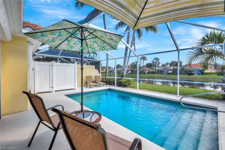 Outdoor pool with a patio area, a water view, and a lanai