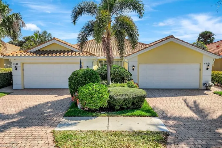 View of front of home featuring a garage, a tile roof, and stucco siding