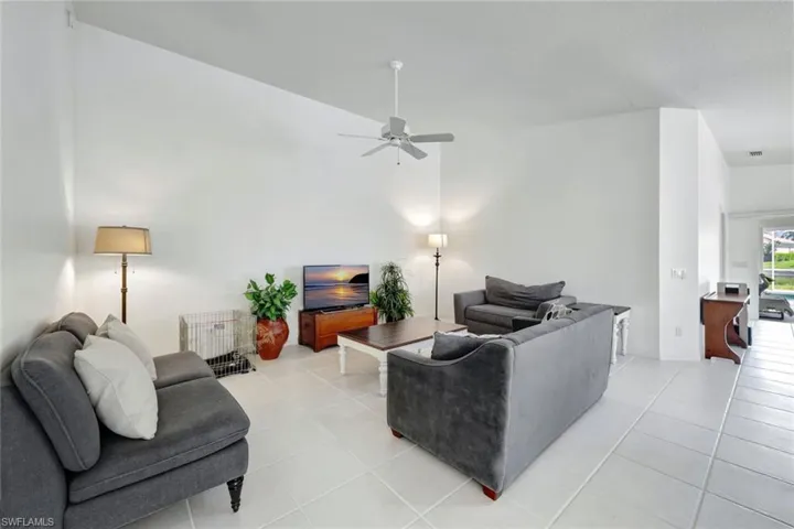 Living area featuring ceiling fan and light tile patterned floors