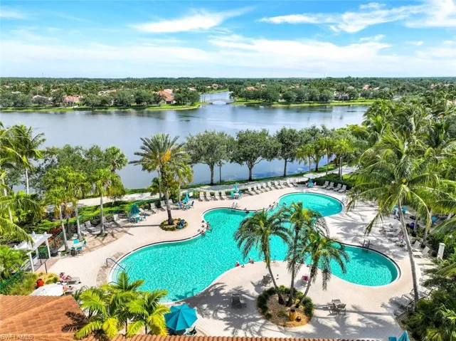 Community pool featuring a patio area and a water view