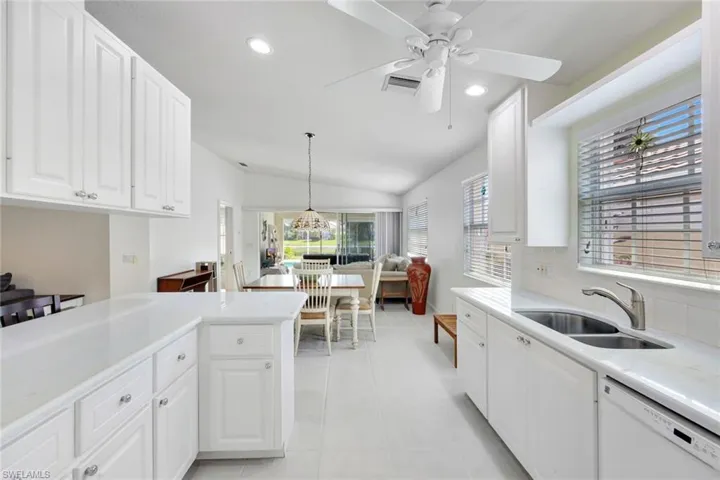 Kitchen with light tile patterned floors, a sink, visible vents, light countertops, and dishwasher