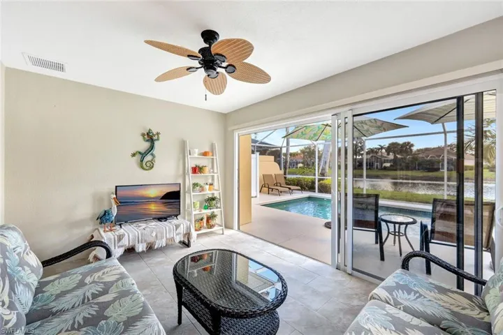 Living area with light tile patterned floors, a sunroom, baseboards, visible vents, and a ceiling fan