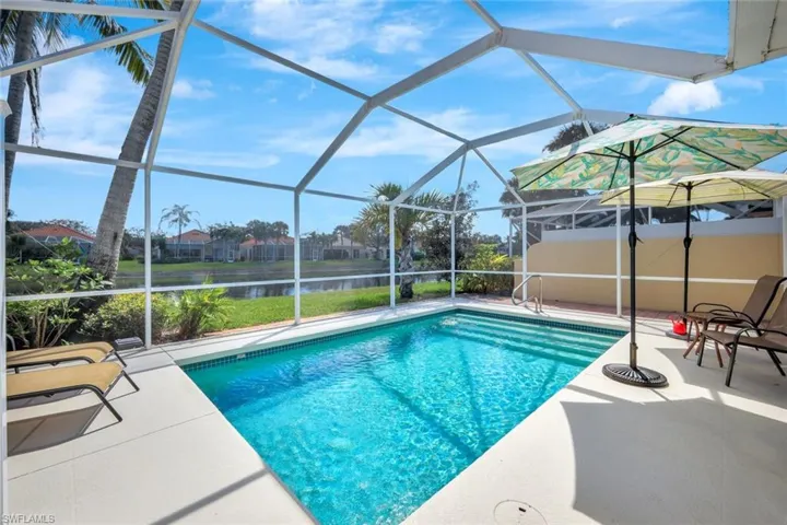 Outdoor pool featuring a water view, a patio area, and a lanai