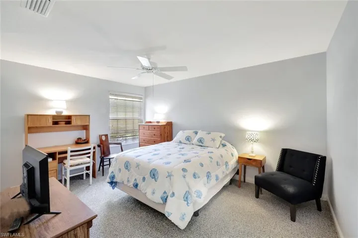 Bedroom with baseboards, visible vents, a ceiling fan, and light colored carpet
