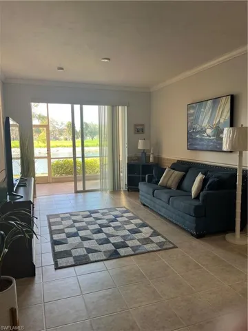 Living area with ornamental molding and light tile patterned floors