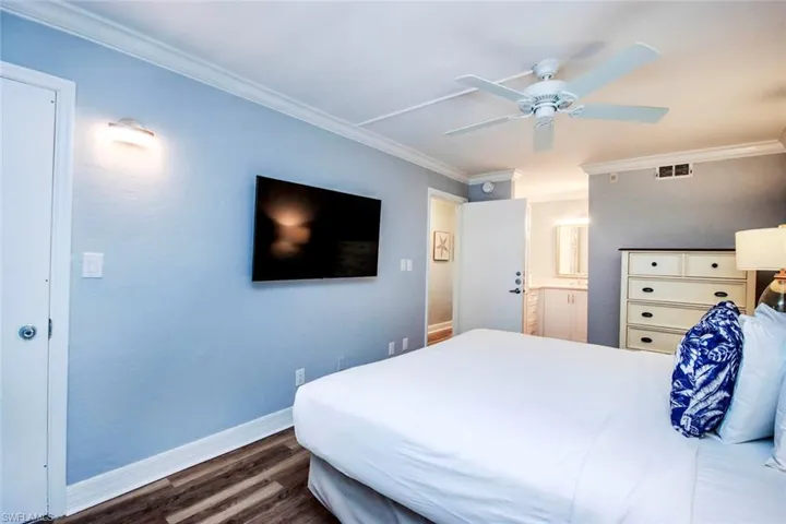 Bedroom featuring LVP flooring molding, and ceiling fan