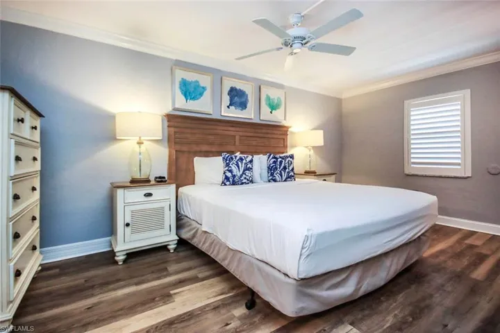 Bedroom featuring ornamental molding, ceiling fan, and LVP floors