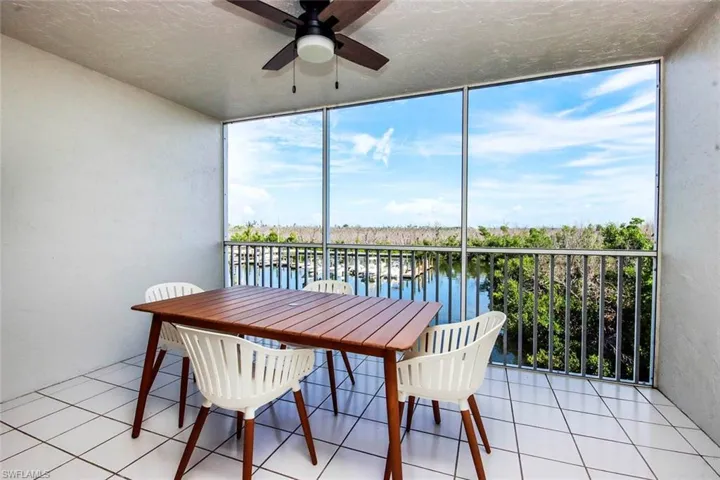 Screened patio featuring a view of the Bayside Marina and the Bay, ceiling fan, and plenty of natural light