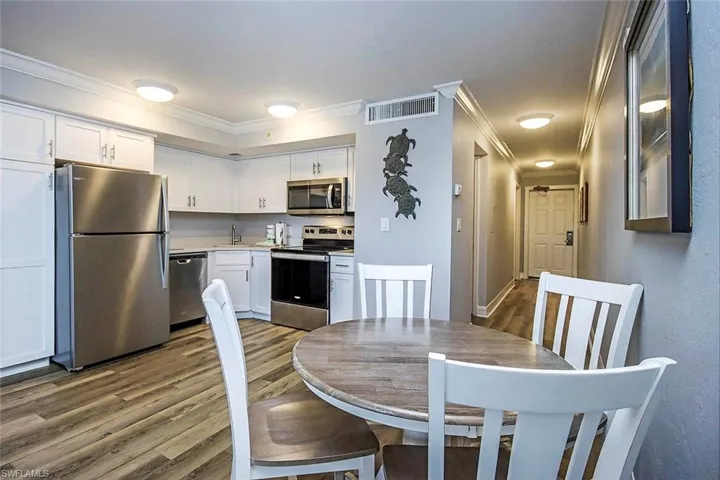 Dining space with sink, crown molding, and LVP floors