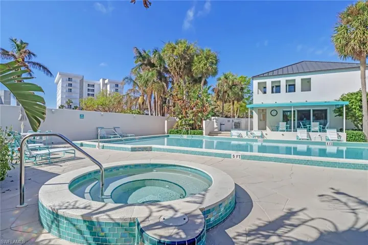 Community pool with a patio and a hot tub