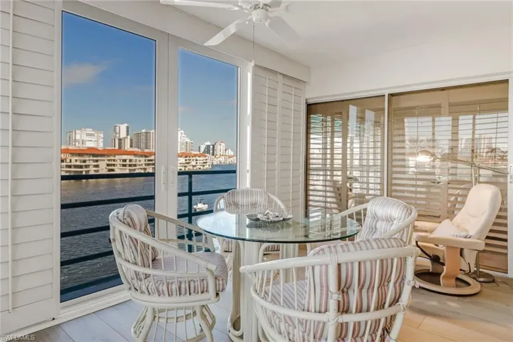 Sunroom with a water view and a view of city