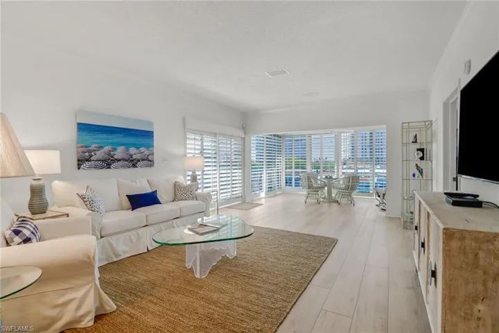 Living area featuring light wood-type flooring, a textured ceiling, and ornamental molding