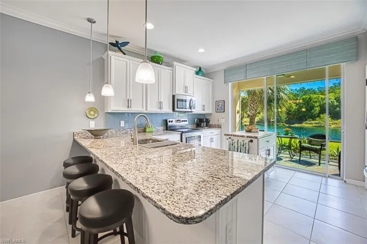 Kitchen with accent paint and stainless steel appliances, white cabinets, and tasteful backsplash