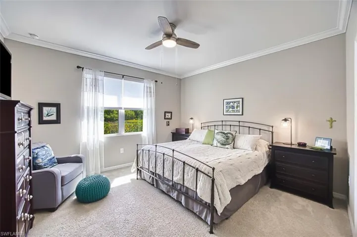 Bedroom featuring light colored carpet, baseboards, and ornamental molding