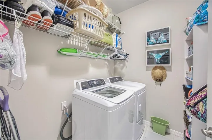 Laundry room with washer and clothes dryer, laundry area, and baseboards